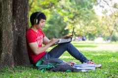 A man studies Chinese online in the sunshine